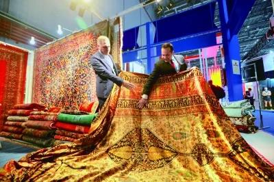 09在文旅展区，伊朗工作人员展示有伊朗图案和中国传统图案的挂毯